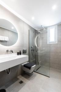 a bathroom with a toilet and a sink and a shower at Bianco Mare Studios-Apartments in Kalivia Poligirou