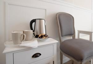 Villa Luce Assisi Rooms & Suites في سانتا ماريا ديجلي آنجيلي: طاولة مع كوبين قهوة وكرسي