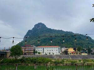 una città con una montagna sullo sfondo con luci di Sky Homestay Ha Giang a Ha Giang