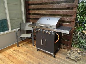 a grill sitting on a patio with a chair at Kustverhuur, Park Schoneveld, Duinroos 153 in Breskens