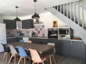 a kitchen with a wooden table and blue chairs at Maison Famille 8 pers, Jardin et Terrasse à Jard-sur-Mer - FR-1-336-104 in Jard-sur-Mer