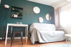 1 dormitorio con cama y pared azul con espejos en Le Green - HyperCentre - Lens République - Confort, en Lens