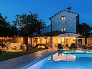 a house with a swimming pool in front of a house at Villa Histria - Adriatic Luxury Villas in Manjadvorci