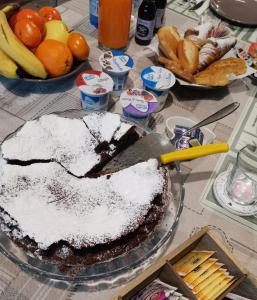 una mesa con un pastel de chocolate con azúcar en polvo. en Il Colibrì Bed&Breakfast en Leno