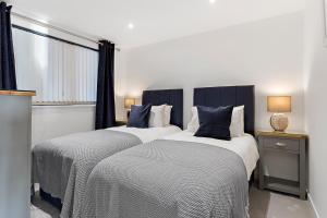 two beds sitting next to each other in a bedroom at Estuary View, 3 Grand Banks in Teignmouth
