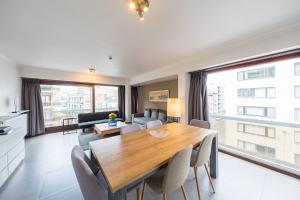 奥斯坦德Duong condo的配有木桌椅的厨房和客厅