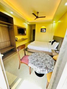 um quarto de hotel com uma cama, uma mesa e cadeiras em Royal Beach International em Puri