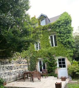 ein Haus mit Bänken davor in der Unterkunft La Closerie un écrin de verdure à 500m de la plage in Sainte-Adresse