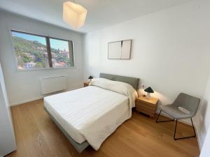 een slaapkamer met een bed, een stoel en een raam bij Gli Scogli Luxury Residence Hotel in Chiavari