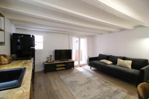 a living room with a couch and a flat screen tv at New design apartment in Barcelona center. in Barcelona