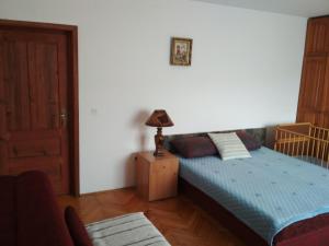 a bedroom with a bed and a lamp on a night stand at Dušanov Konak in Bajina Bašta