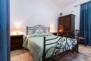 a bedroom with a bed with a green comforter at Agriturismo Villa Gaia in Càbras