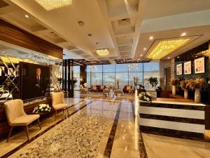 a lobby of a hotel with chairs and a large window at Jeddah Homes Boutique Hotel in Amman