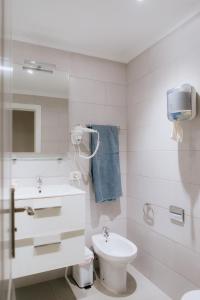 biała łazienka z umywalką i toaletą w obiekcie Endless Summer Vibes w Adeje
