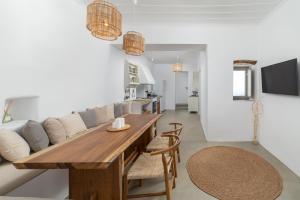 een woonkamer met een houten tafel en een bank bij Villa Stefano La Fleur Andros in Ándros