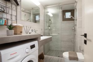 a bathroom with a shower and a washing machine at Diov Bohali House in Zakynthos Town +6 photos