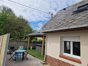 patio ze stołem i krzesłami w ogrodzie w obiekcie Gîte les 4 sabots de la Baie w mieście Bourseville