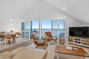 a living room with a television and a table with chairs at Ocean View Villa, 2 bedroom in Mandurah