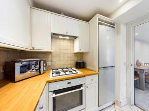 a kitchen with white cabinets and a stove top oven at 18 Palm Hill, Oxton in Upton