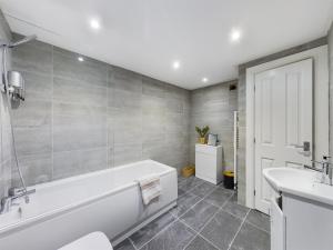 a bathroom with a white bath tub and a sink at 18 Palm Hill, Oxton in Upton