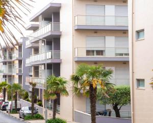 an apartment building with palm trees in front of it at 1 Bed Boutique-style Apartment in São Martinho do Porto