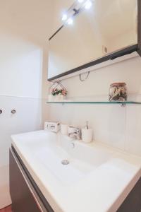 a bathroom with a white sink and a mirror at Appartamento Angelina in Menaggio