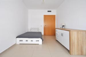 a bedroom with a bed and a wooden cabinet at Santa Clotilde in Lloret de Mar +31 photos