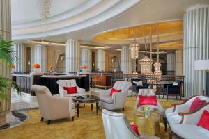 a lobby with chairs and tables and a bar at The St. Regis Abu Dhabi in Abu Dhabi