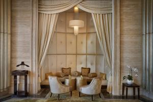 a living room with a couch and a table and chairs at The St. Regis Abu Dhabi in Abu Dhabi