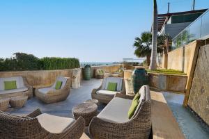 d'une terrasse avec des chaises et des tables en osier et l'océan. dans l'établissement The St. Regis Abu Dhabi, à Abu Dhabi