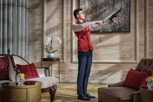 a man standing in a living room holding a bottle at The St. Regis Abu Dhabi in Abu Dhabi