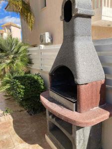 um forno de pizza em pedra sentado num pátio em Anna Villa em Protaras
