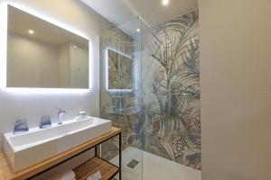 a bathroom with a sink and a mirror at Hotel Onda in Calvi