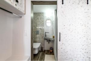 La salle de bains est pourvue de toilettes blanches et d'un lavabo. dans l'établissement Petit Sunset, à Ioulída