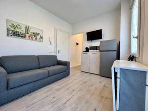 a living room with a couch and a refrigerator at Condominio Sporting in Lignano Sabbiadoro