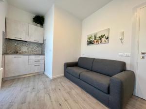 a living room with a couch and a kitchen at Condominio Sporting in Lignano Sabbiadoro