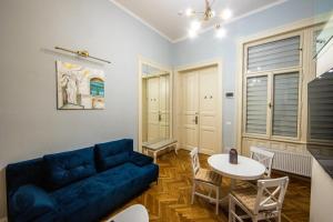 ein Wohnzimmer mit einem blauen Sofa und einem Tisch in der Unterkunft VISAJ Deluxe Downtown in Timişoara