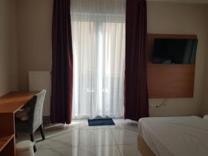 a bedroom with a bed and a desk and a window at Hotel Emiliana am Bahnhof in Frankfurt