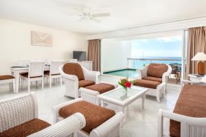 una sala de estar con muebles blancos y vistas al océano. en 2 bedrooms appartement with sea view indoor pool and furnished balcony at Lowlands en Lowlands