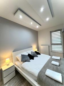 - une chambre avec un grand lit blanc et des oreillers noirs dans l'établissement Wola Residence, à Varsovie