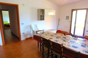 a dining room with a table and chairs and a room at Modern Apartment with Pool near Cardedu - 85 sqm in Cardedu +3 photos