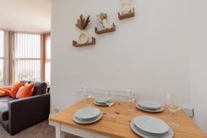 a dining room with a table with plates and wine glasses at Cherry Property - Grapefruit Suite in Blackpool