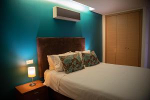 a bedroom with a bed with a blue wall at 1 Bed Boutique-style Apartment in São Martinho do Porto +43 photos