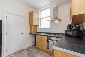 a kitchen with a sink and a stove top oven at Cherry Property - Grapefruit Suite in Blackpool