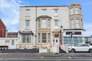 a white car parked in front of a building at Cherry Property - Grapefruit Suite in Blackpool