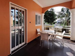 a dining room with orange walls and a table and chairs at Agbata Guest House 