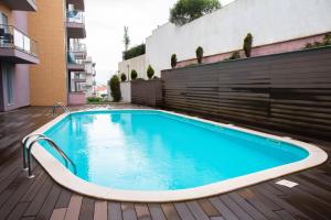 a swimming pool on a deck next to a building at 1 Bed Boutique-style Apartment in São Martinho do Porto