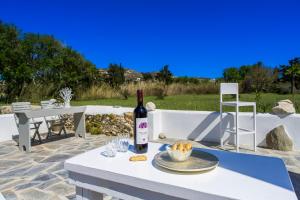 a bottle of wine on a table with a plate of food at Bonzoe #4 in Parikia