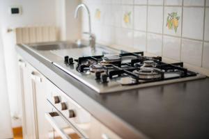 un piano cottura in una cucina con lavandino di Adriatico Home[Mare-Fiera-Centro] a Bari