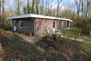 une petite cabane en bois avec une table de pique-nique dans la cour dans l'établissement De Boomklever, à Zorgvlied